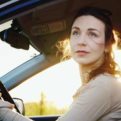 attractive woman looks out the car window portrait 1