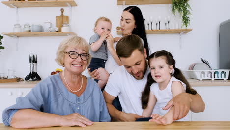 familia feliz mirando la cámara mientras tiene una videollamada divertida en la cocina