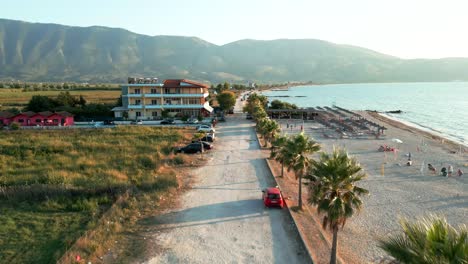 albania, road along the beach, palm trees, sea, and mountains in the background