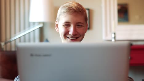 happy smiling teenager reacting to something on the laptop screen