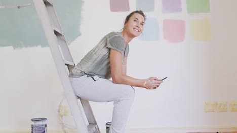 Portrait-of-a-Caucasian-woman-in-quarantine-during-coronavirus-pandemic,-doing-interior-work