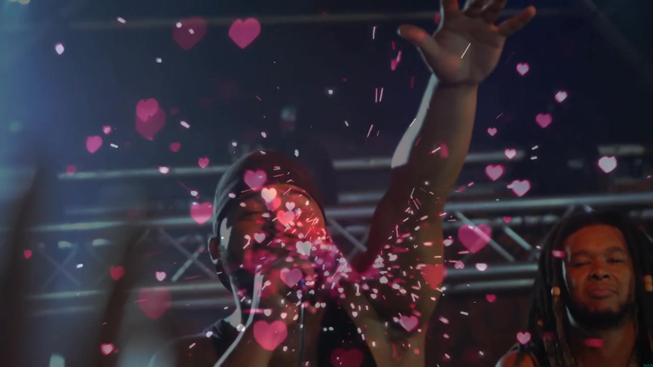 Heart confetti bursting in live concert, lead vocalist holding mic and delivering opening line