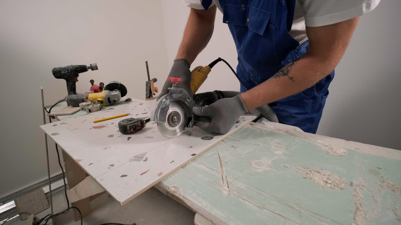 Construction, renovation, repair apartment. Installing ceramic floor tiles - measuring and cutting the pieces. Cuts tile. Tile cutting
