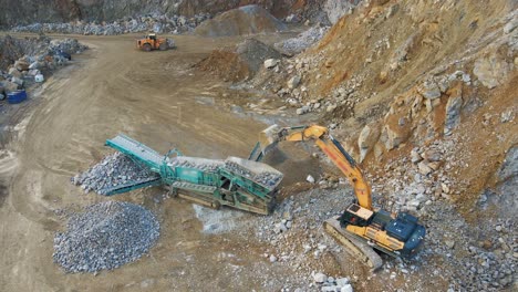 efficient material handling: an excavator, tracked incline screener, and wheel loader at work in a mining quarry in germany