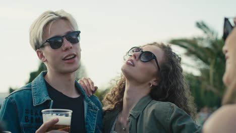 group of young caucasian friends chatting and  having fun on music festival.