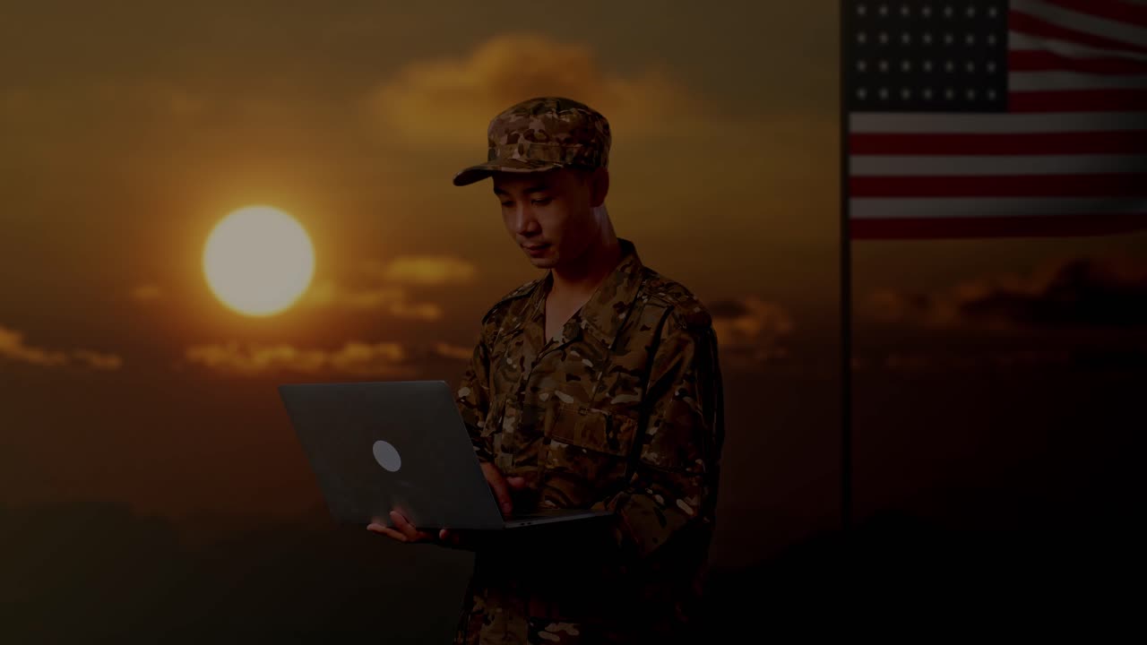 soldado trabajando en una computadora portátil durante el atardecer