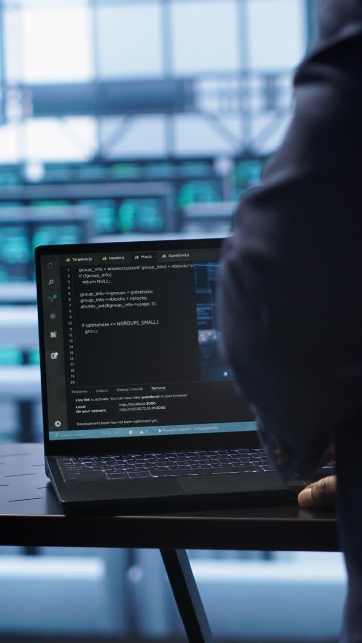 Programmer Coding on Laptop in Modern Tech Office