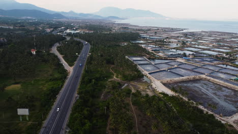 Vista-Aérea-Sobre-Una-Autopista-Junto-A-Las-Minas-De-Sal-A-Lo-Largo-De-Las-Tierras-Costeras-De-Vietnam-Cerca-Del-Parque-Nacional-Chua