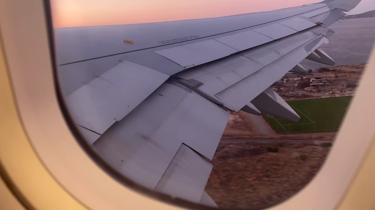 airplane wing during departure over Heraklion Crete Greece with coastal landscape below