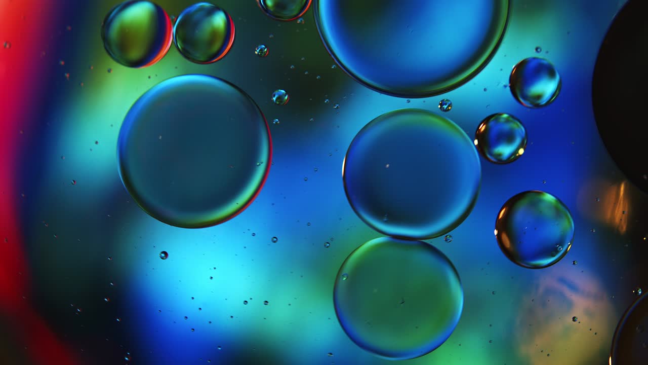 Gocce di olio alimentare colorate astratte, bolle e sfere che scorrono