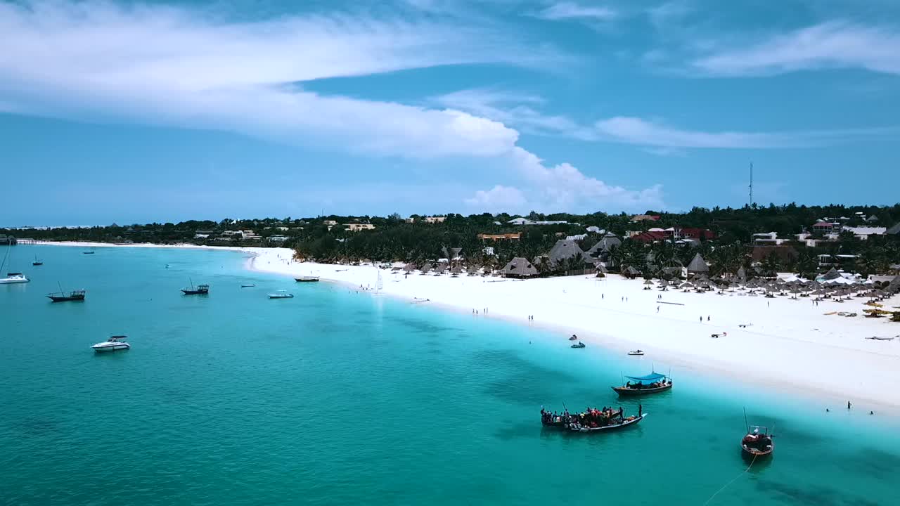 increíble vuelo aéreo vuela desde arriba hacia abajo con un dron de grúa disparado sobre aguas turquesas cristalinas y un paraíso de playa de arena blanca en zanzíbar, áfrica cinemática aérea filmada 1080, 60 en philipp marnitz