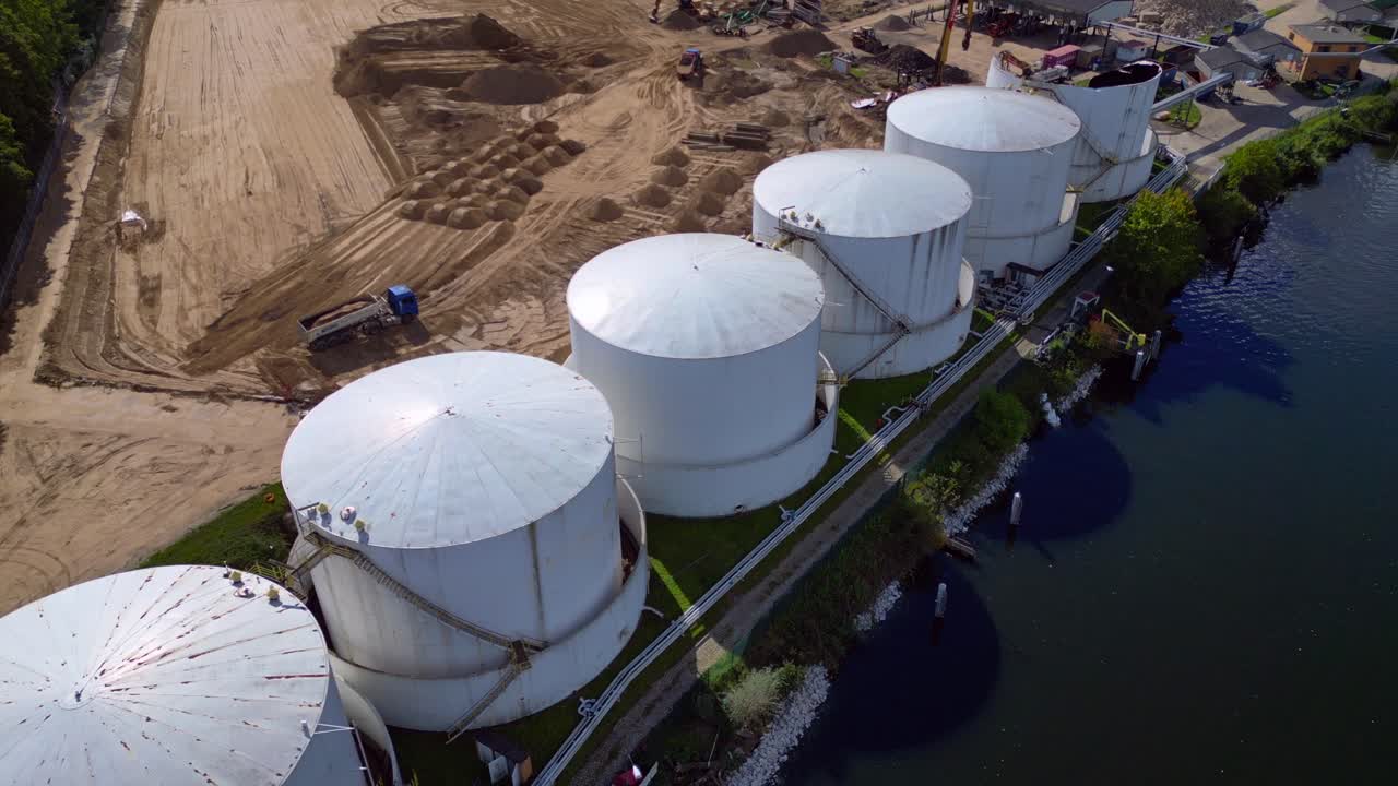Decommissioning of Storage depot for petroleum products storage silos and containers. Industrial storage tanks holding oil and gas products. Amazing aerial view flight fly reverse drone
