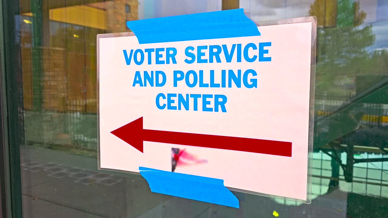 Stock footage of a clear civic sign reading “Voting Service Polling Center” with a large arrow pointing the way, symbolizing guidance, democracy, and accessible directions for registered voters