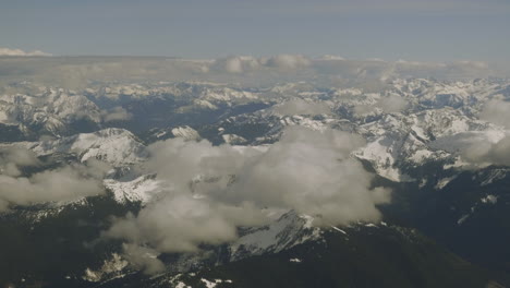 Rocky-mountains-stretching-on-for-miles-under-the-thin-wispy-clouds-view-from-the-airplane