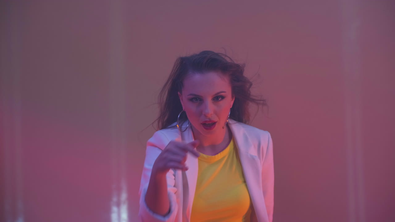 mujer sonriente bailando en el estudio. niña cantando una canción sobre fondo amarillo. mujer celebrando representa la alegría y la felicidad. concepto de fiesta de éxito.