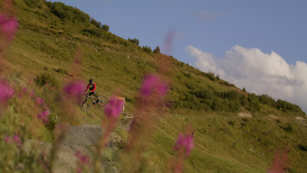 Man riding downhill mountain bike in Verbier during a stunning sunset, surrounded by epic alpine landscapes and golden mountain light.