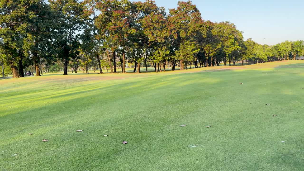 Prospettiva in prima persona da un golf cart in movimento che attraversa un lussureggiante fairway verde al tramonto