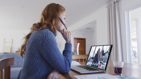mujer caucásica usando portátil y auriculares de teléfono en videollamada con una colega