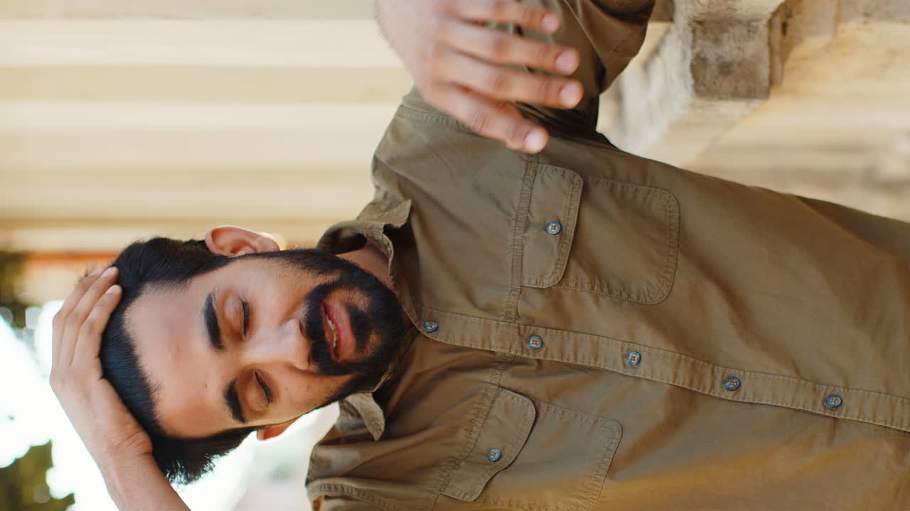 Sad unhappy frustrated indian man standing alone in city street feeling bad annoyed grief problem