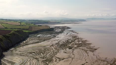 Drone-shot-while-moving-left-to-right-over-Kilve-beach-and-its-sea-cliffs-in-North-Devon,-UK