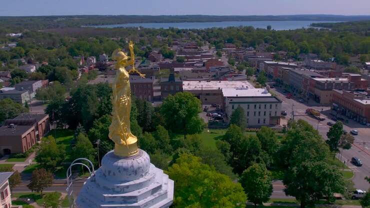 360 degree drone shot of Lady justice gold statue on top of the Beautiful Ontario County Courthouse in Canandaigua, New York near Canandaigua Lake