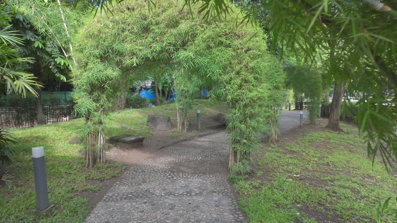 Video 4K dari taman tropis yang menenangkan dengan gapura dan jalan setapak di Manila, Filipina