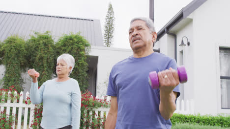 happy senior diverse couple exercising in garden