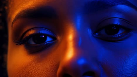 close up of a woman's eyes with blue and orange light