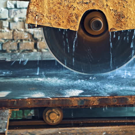 automated circular saw cuts the stone slab at industrial factory. process of cutting stove with water. circle wheel of electric machine for cutting stone slab.