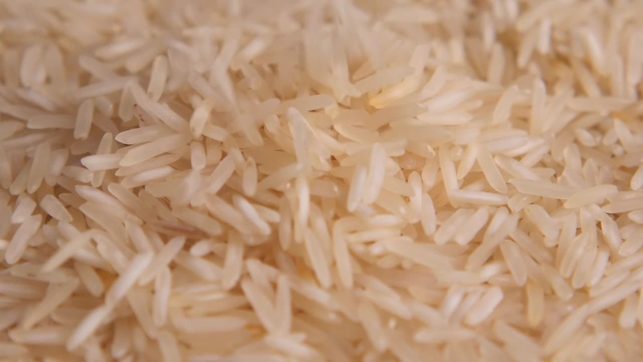 Primer plano de granos de arroz blanco cayendo.
