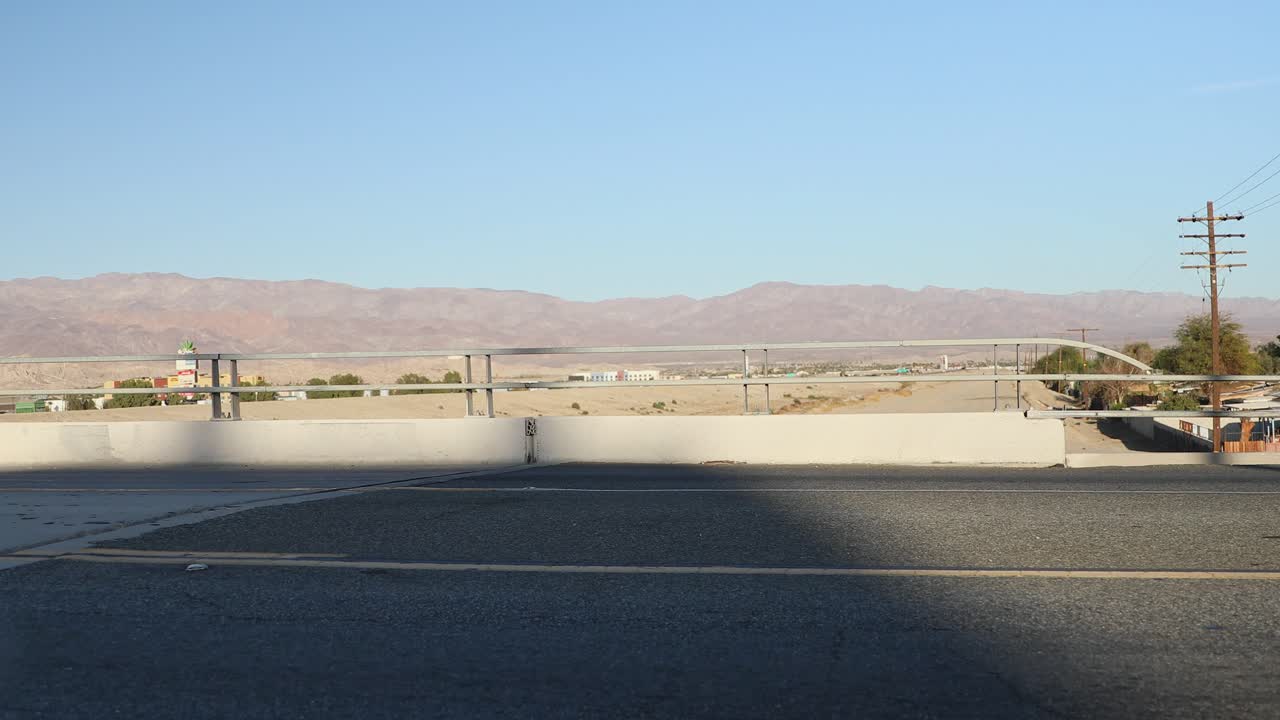 Cars drive in desert landscape on Interstate 10 highway near Indio, California
