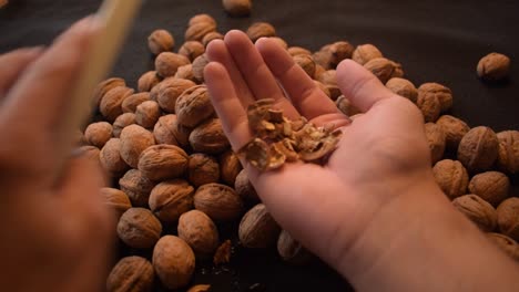 Young man is cracking some fresh dried walnuts-6