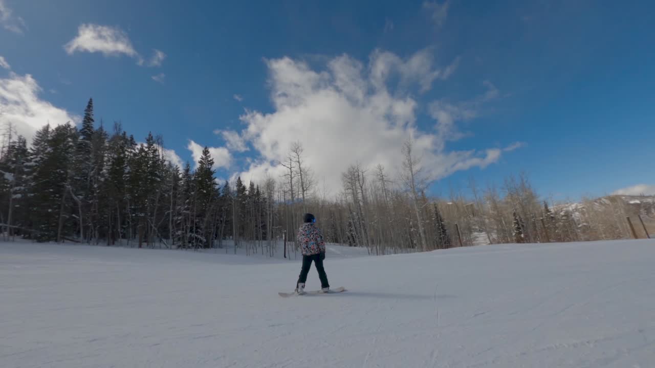 Snowboarder doing spins and tricks down slope, Aspen, Colorado