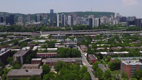 Aerial-view-tilting-toward-the-Église-Sainte-Cunégonde-Church,-in-Little-Burgundy,-Montreal
