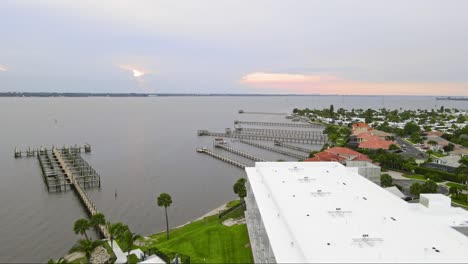 a beautiful overhead drone shot of vacation rentals and hotels with a pool outside and palm trees with water near by in melbourne florida