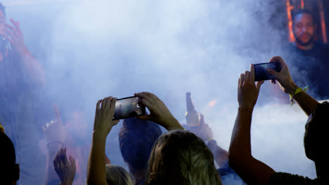 audience recording video of musical band on mobile phone 4k