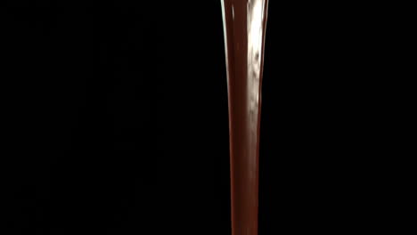 melted chocolate pouring on black background