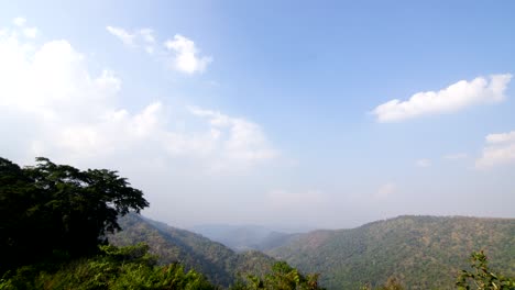 a wide angle shot of clouds passing by the mountains midday
