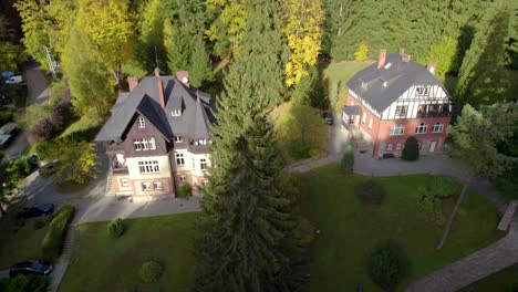 aerial trucking shot of the beautiful xix century villas hidden in the mountain forest in autumn