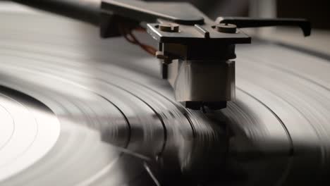 stylus needle on vinyl record playing with disc rotating close up