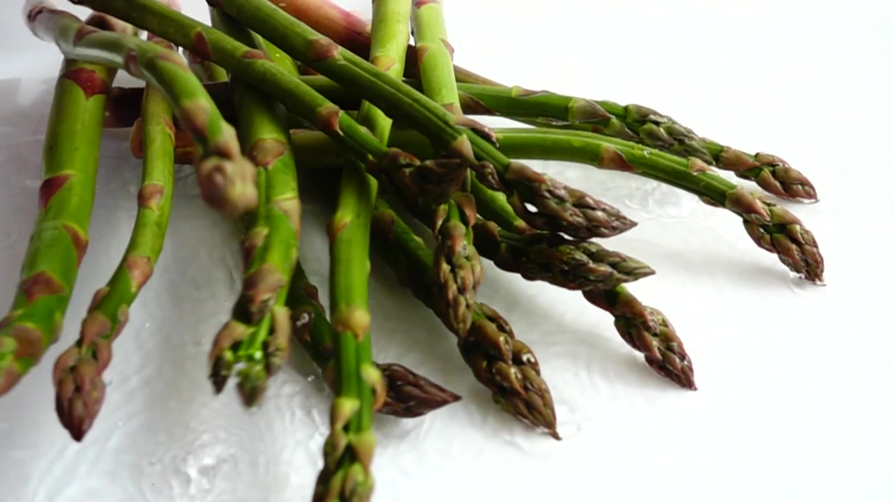 Asparagi verdi freschi. Schizzi d'acqua. Al rallentatore