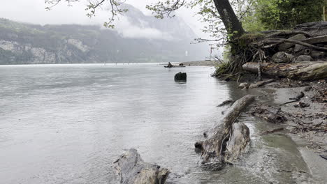 Tranquila-Y-Relajante-Orilla-Del-Lago-Walensee-Adornada-Por-Lluvias-Torrenciales,-Madera