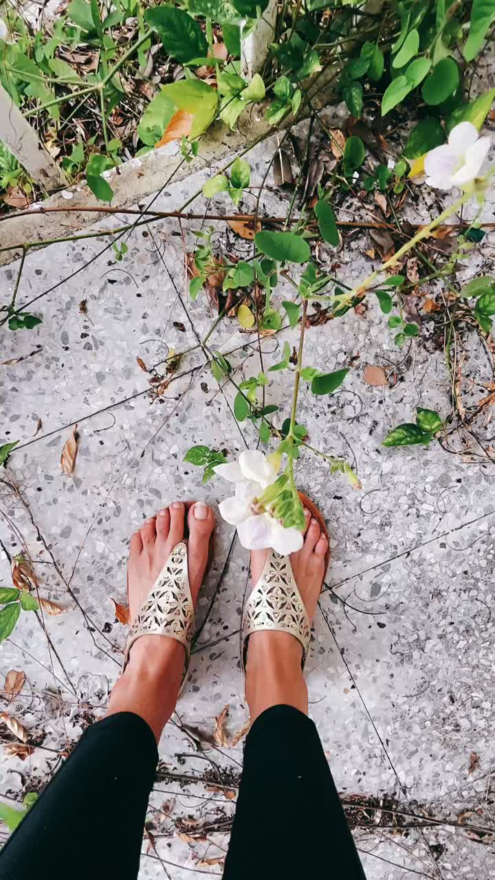 Woman's Feet in Sandals in a Garden