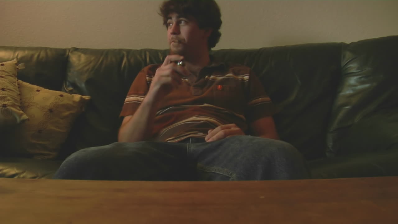 una mujer embarazada con una máscara de gas se sienta junto a un hombre que fuma