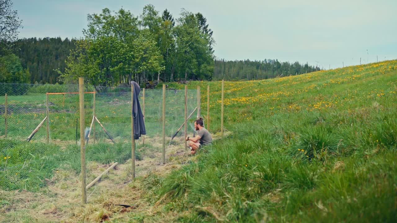 Timelapse Of Man Constructing A Fence With Metal Wire Mesh