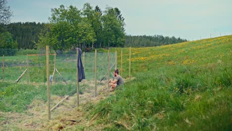 Timelapse Of Man Constructing A Fence With Metal Wire Mesh