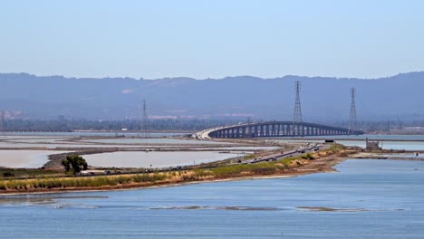 Dumbarton-Bridge-Aus-Der-Ferne-Schlängelt-Sich-über-Die-Bay-Area,-Während-Autos-Und-Lastwagen-Die-Autobahn-überqueren