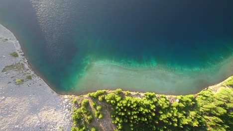 aerial top down pan sideways green blue alpine lake carnarvon lake, kananaskis, alberta, canada