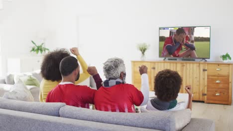 video of african american family sitting on the couch and watching football match