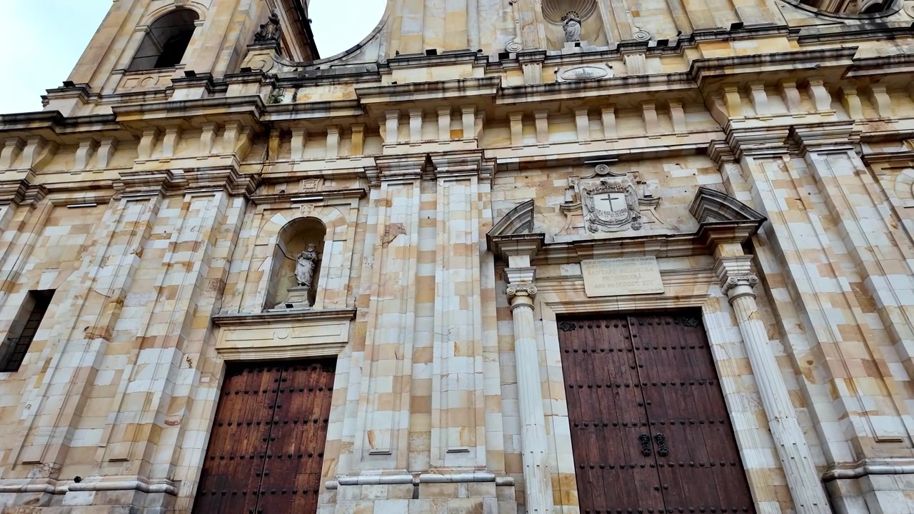 Primo piano dell'intricata lavorazione in pietra e delle porte in legno della storica cattedrale neoclassica in Plaza de Bolivar